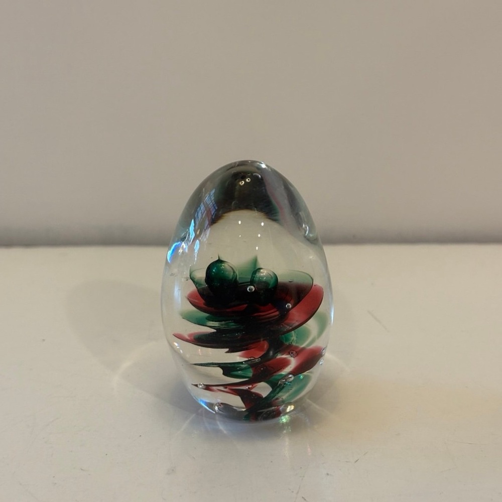 Glass egg shaped clear read and green swirl paperweight